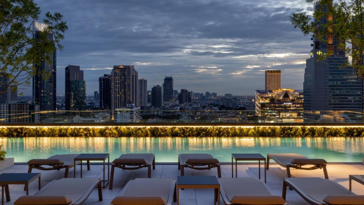 Immergersi nella piscina e ammirare la bellezza di Bangkok al tramonto