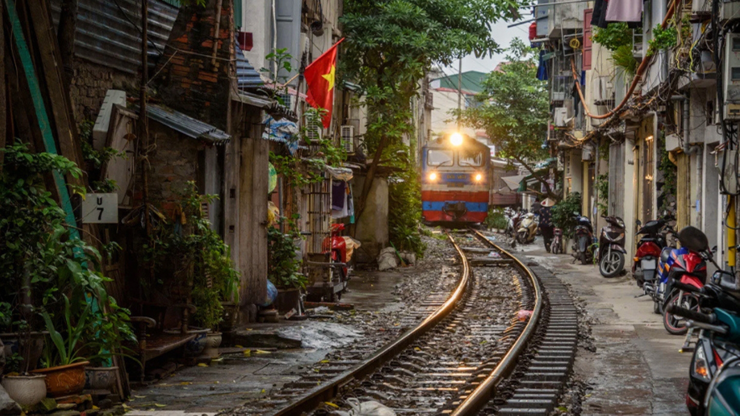 Il treno attraversa una stretta strada nel cuore di Hanoi.