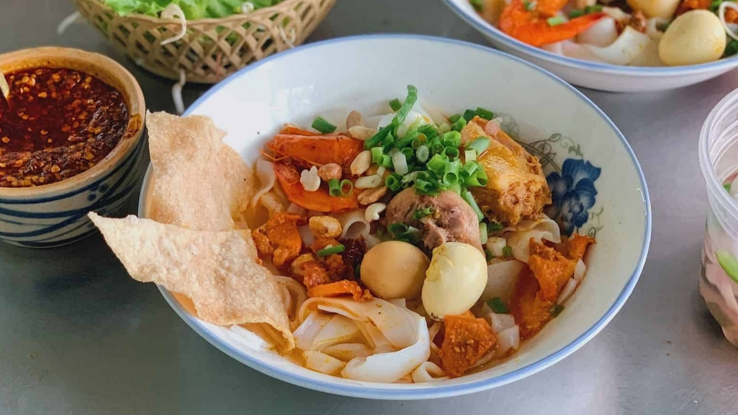 Un'immagine di una ciotola di Mì Quảng misto completo a Da Nang 