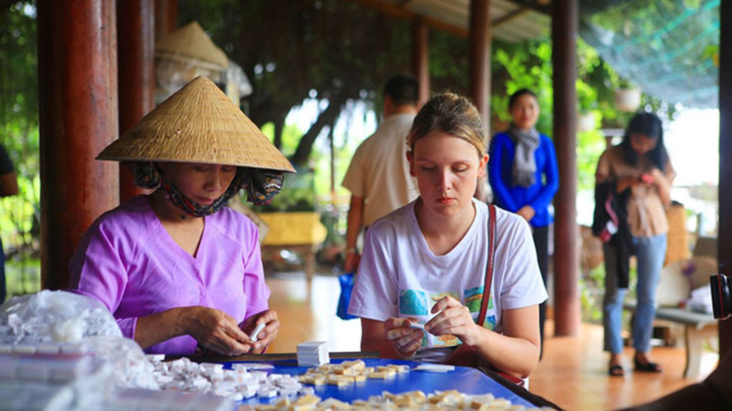 I turisti possono cimentarsi nella preparazione di caramelle al cocco a Ben Tre